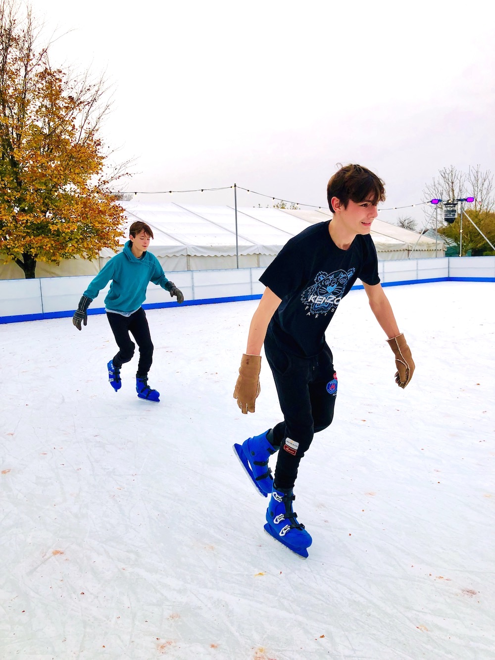 Two boys enjoying open air Christmas ice skating at Avon Valley, Bristol