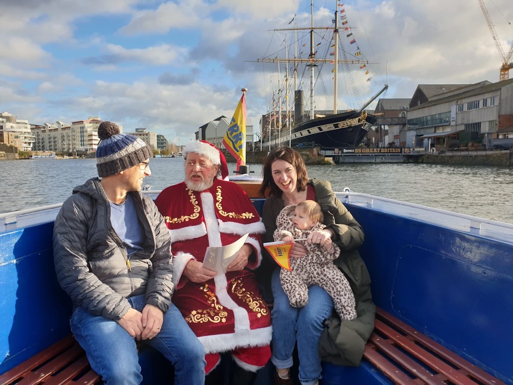 Bristol Ferry Sail with Santa featuring a man, woman and baby on a ferry with Father Christmas in Bristol Harbour
