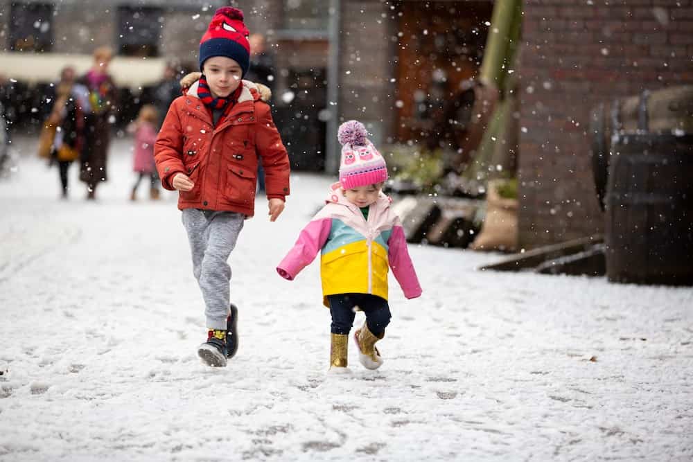 Children in falling snow at SS GReat Britain's Victorian Christmas in Bristol