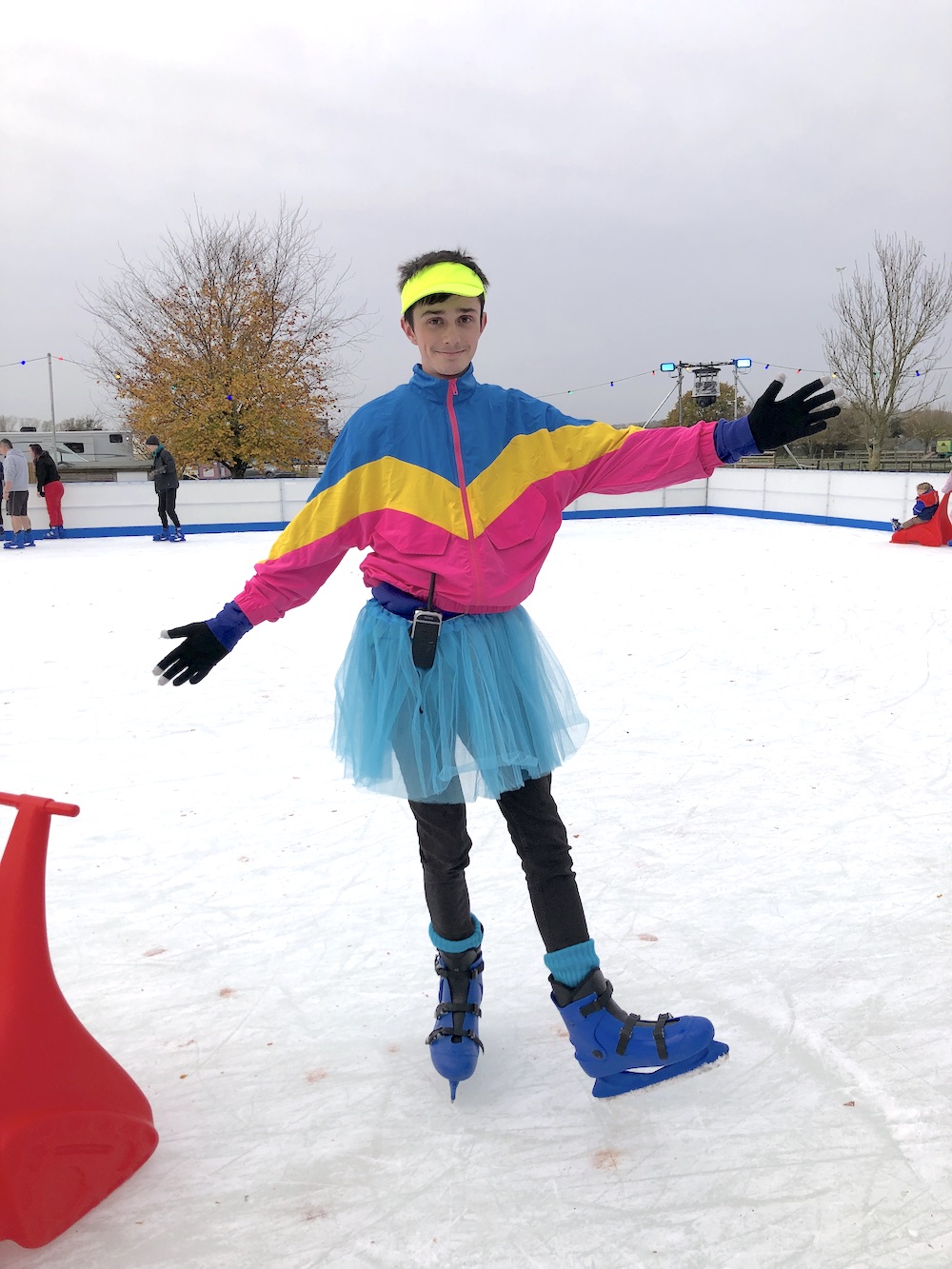 Man sporting fluorescent eighties clothing and a blue tutu at the Outdoor Festive Ice Skating Rink at Avon Valley Park in Bristol